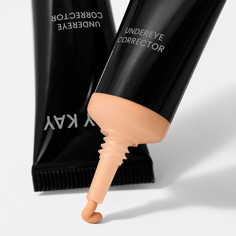 Corrector Undereye Mary Kay&reg; en el tono Light Peach con el producto saliendo del envase.